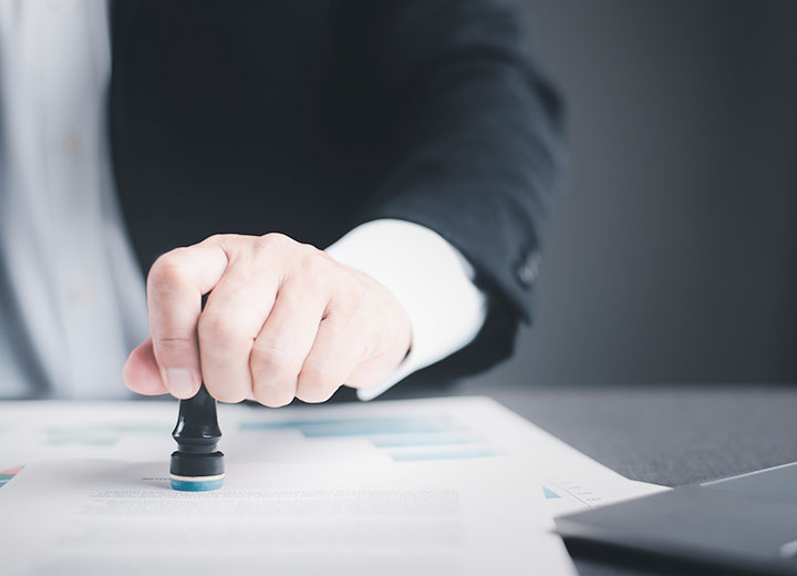 Carimbo de pessoas de negócios nos documentos do contrato na mesa, o conceito de confirmação ou aprovação do contrato, a autoridade de autorização de solicitação.