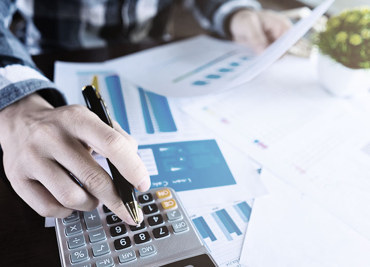 mão de homem branco utilizando a calculadora