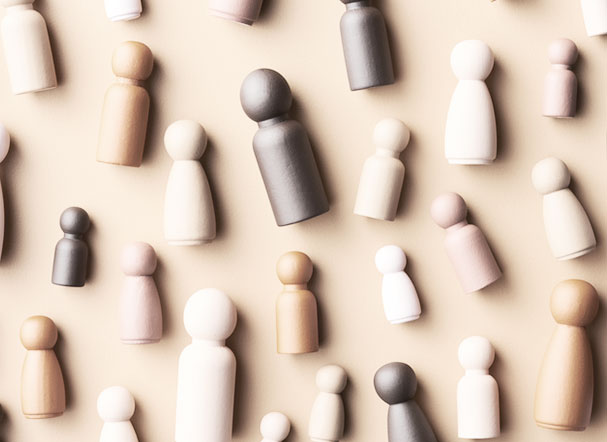 Chess pieces positioned side by side on a table, with variations in shades of brown, white and beige