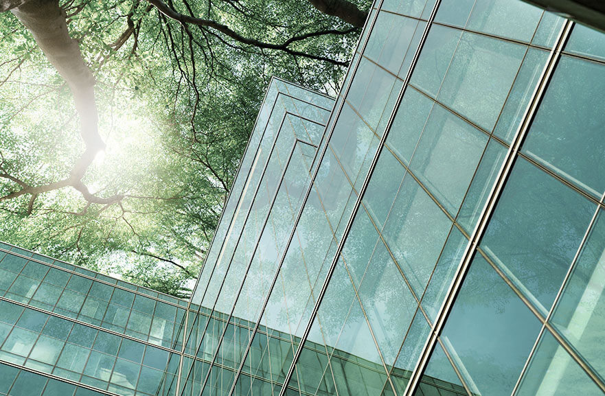 Bottom view of mirrored building with tree in the background