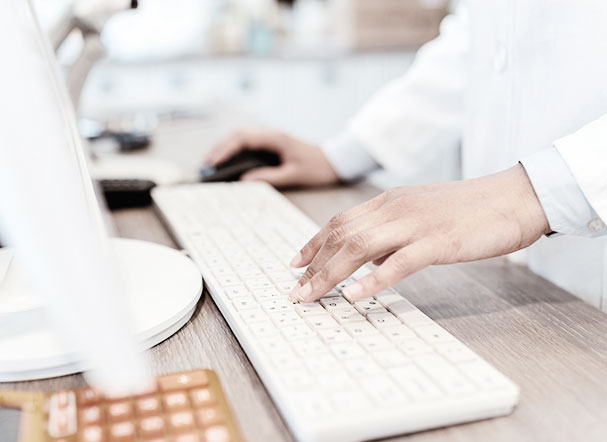 farmaceutico digitando em teclado de cor branca